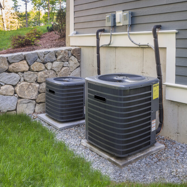 Residential heating and air conditioner compressor units near suburban house