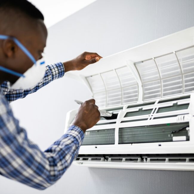 Man fixing an indoor air conditioning unit