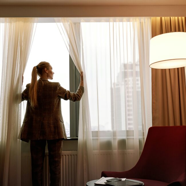 Woman looking outside a window in a hotel