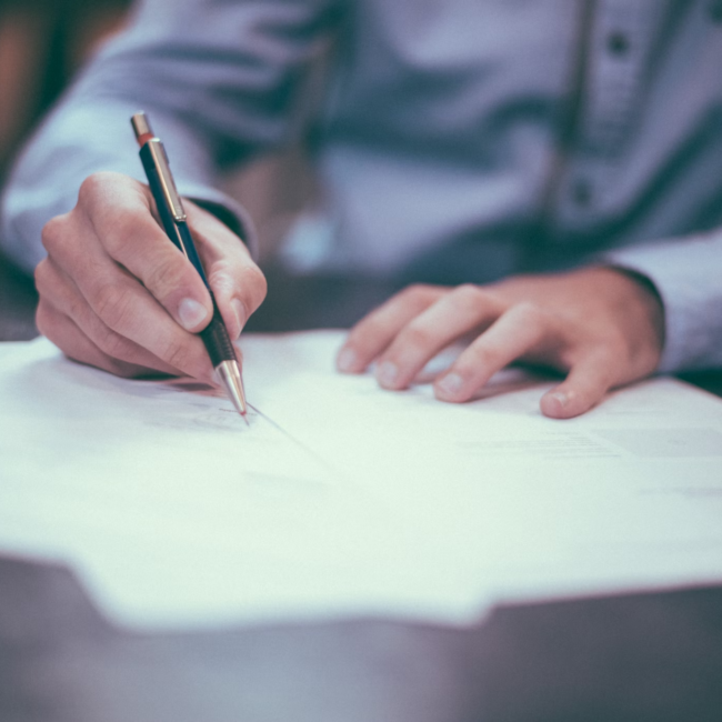 person with a pencil writing
