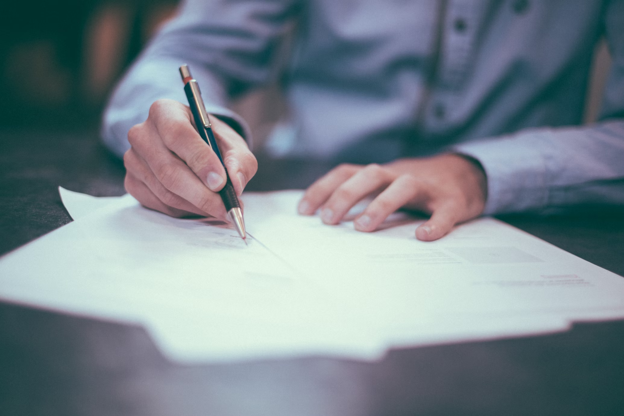 person with a pencil writing