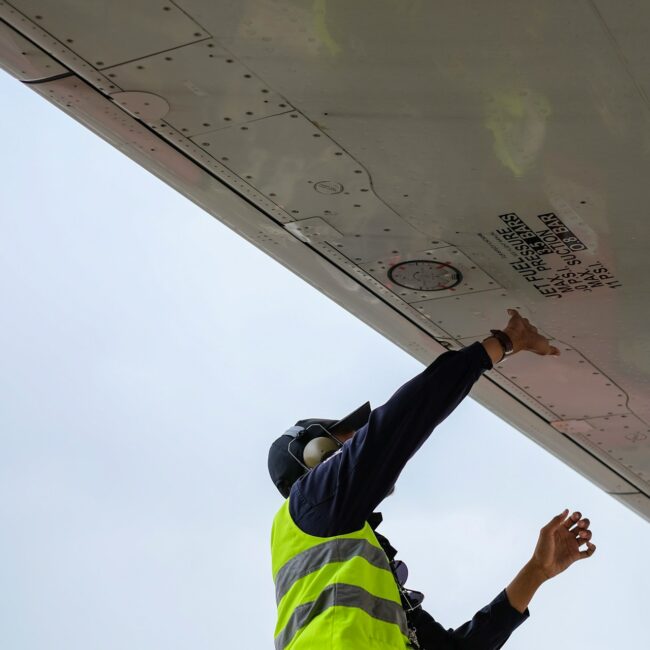 A technician performing maintenance on an HVAC system, inspecting and adjusting components inside.